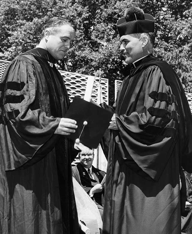 Then–Notre Dame president Rev. Theodore Hesburgh (right), shown here giving an honorary degree to Sargent Shriver in 1961, gathered together a group of Catholic academic leaders in Land O’ Lakes, Wisconsin, to declare independence from Church authority. (