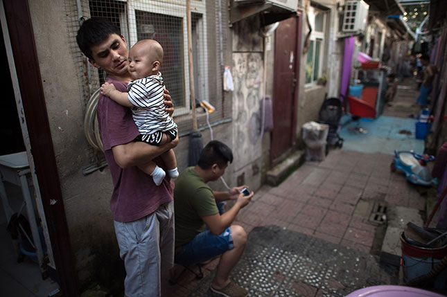 The rapid migration from China’s countryside to its cities has created neighborhoods of intense poverty, often with several people occupying single rooms. (NICOLAS ASFOURI/AFP/GETTY IMAGES)