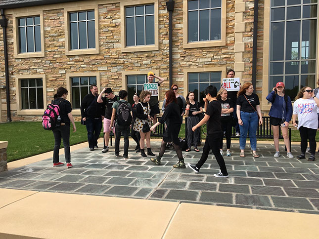 Students (wearing black, in mourning for the liberal arts) assemble for a peaceful protest at Collins Hall, the central administration building. (Photo: Courtesy of author)