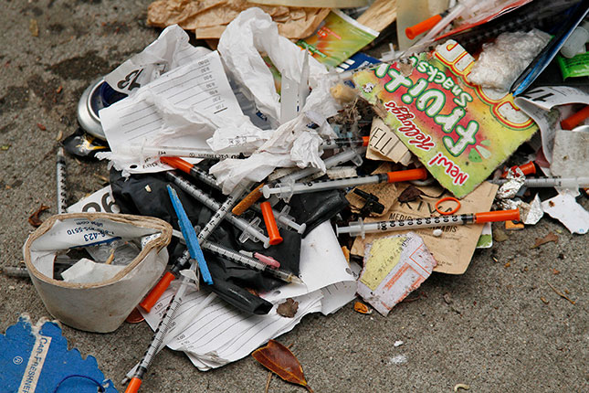 The city dispenses free needles to addicts, who often dispose of them, still filled with heroin and blood, on the streets. (ERIC RISBERG/AP PHOTO)