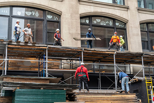 Without cranes, workers often haul heavy materials by hand. (Richard Levine/Alamy Stock Photo)