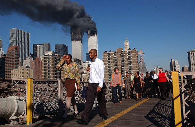 People flee Manhattan over the Brooklyn Bridge as the World Trade Center burns on September 11, 2001. (SPENCER PLATT/GETTY IMAGES)