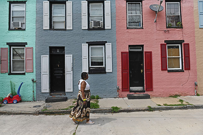 Eaddy walks past the Sarah Ann Street alley homes in Poppleton. (Kenneth K. Lam/The Baltimore Sun)