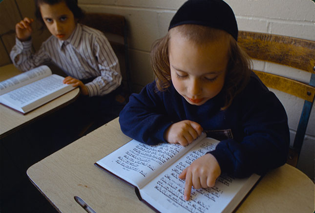 A pupil studying a prayer book (ANDREW LICHTENSTEIN/CORBIS/GETTY IMAGES)